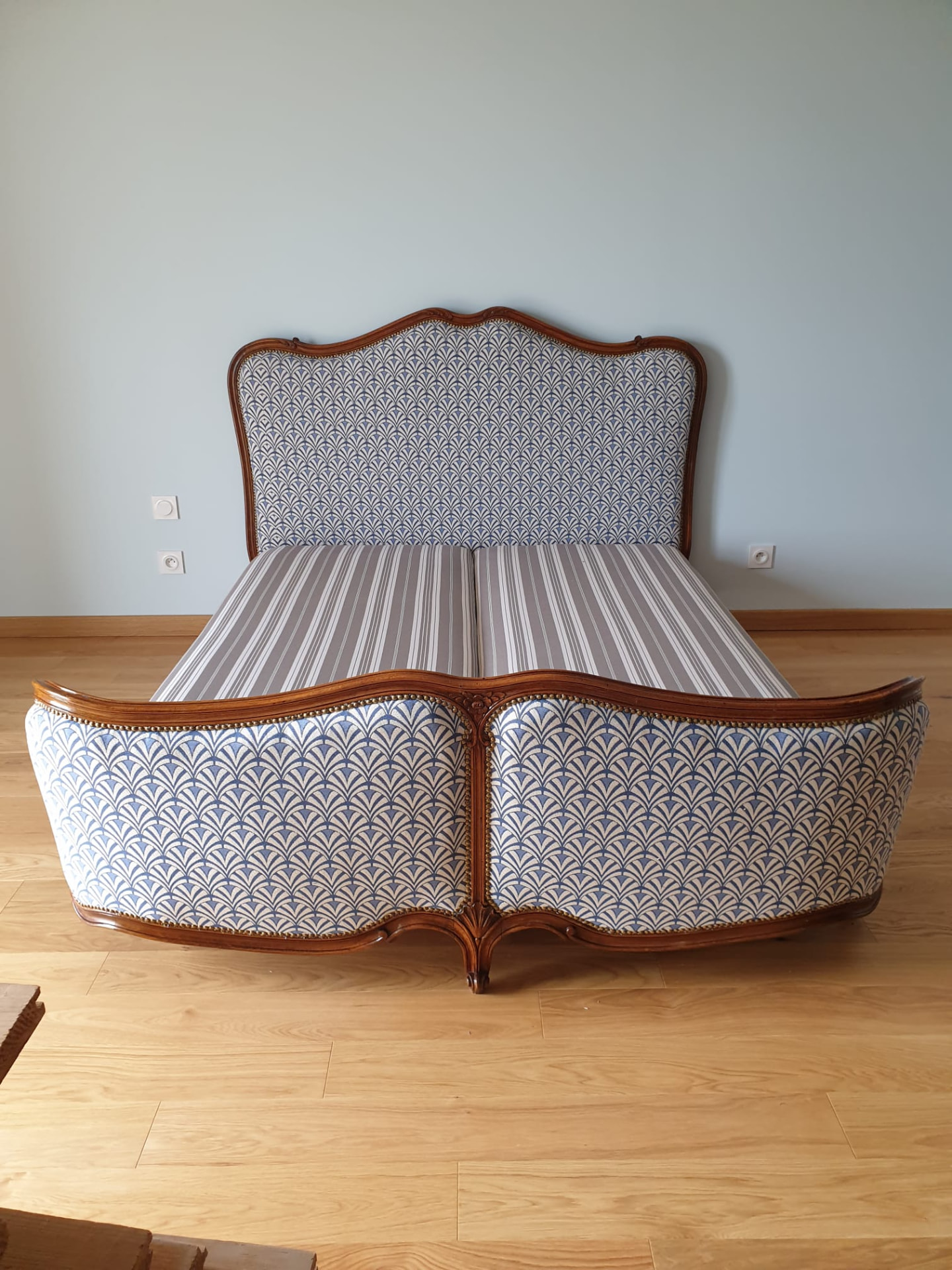 Lit Louis XV en noyer capitonné d'un tissu bleu et blanc, restauré par L'Atelier Artisanal